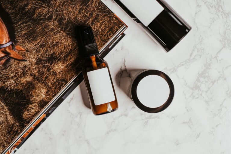 A stylish flatlay of skincare products with a magazine on a marble surface, ideal for product mockups.