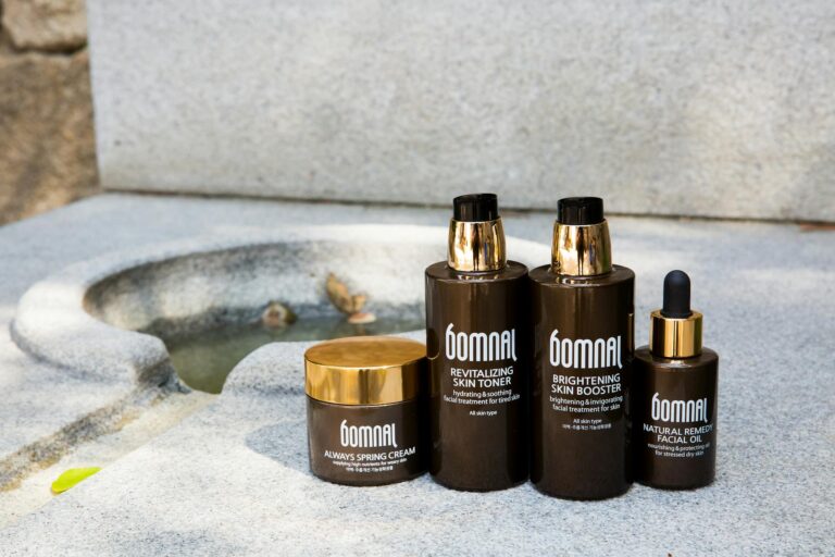 A stylish still life of skincare products arranged outdoors, featuring bottles and creams.