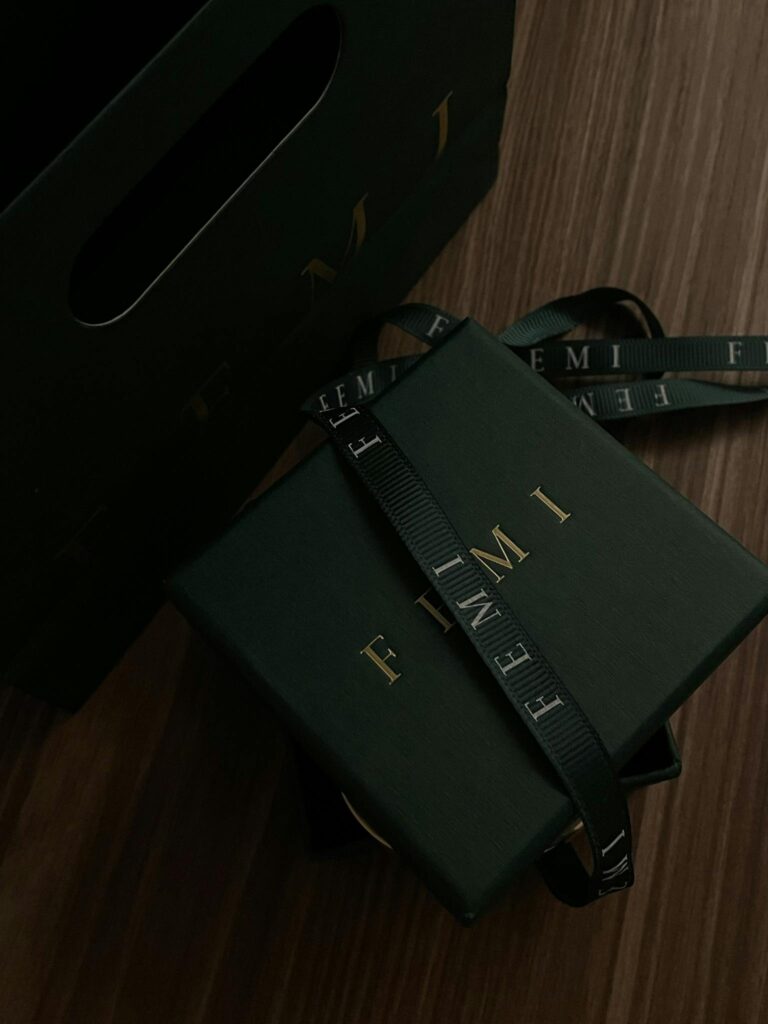 Luxurious dark green gift box with ribbon on a wooden surface, perfect for special occasions.